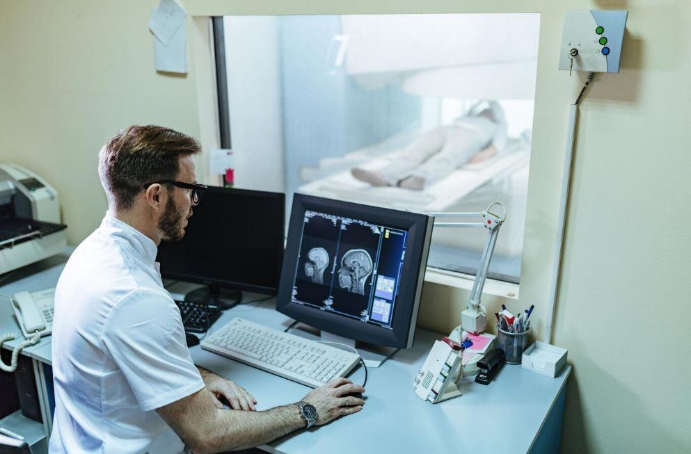 Lékař sleduje snímky. Lékaři zkoumají, jak zastavit roztroušenou sklerózu. Pomůže jim v tom i magnetická rezonance