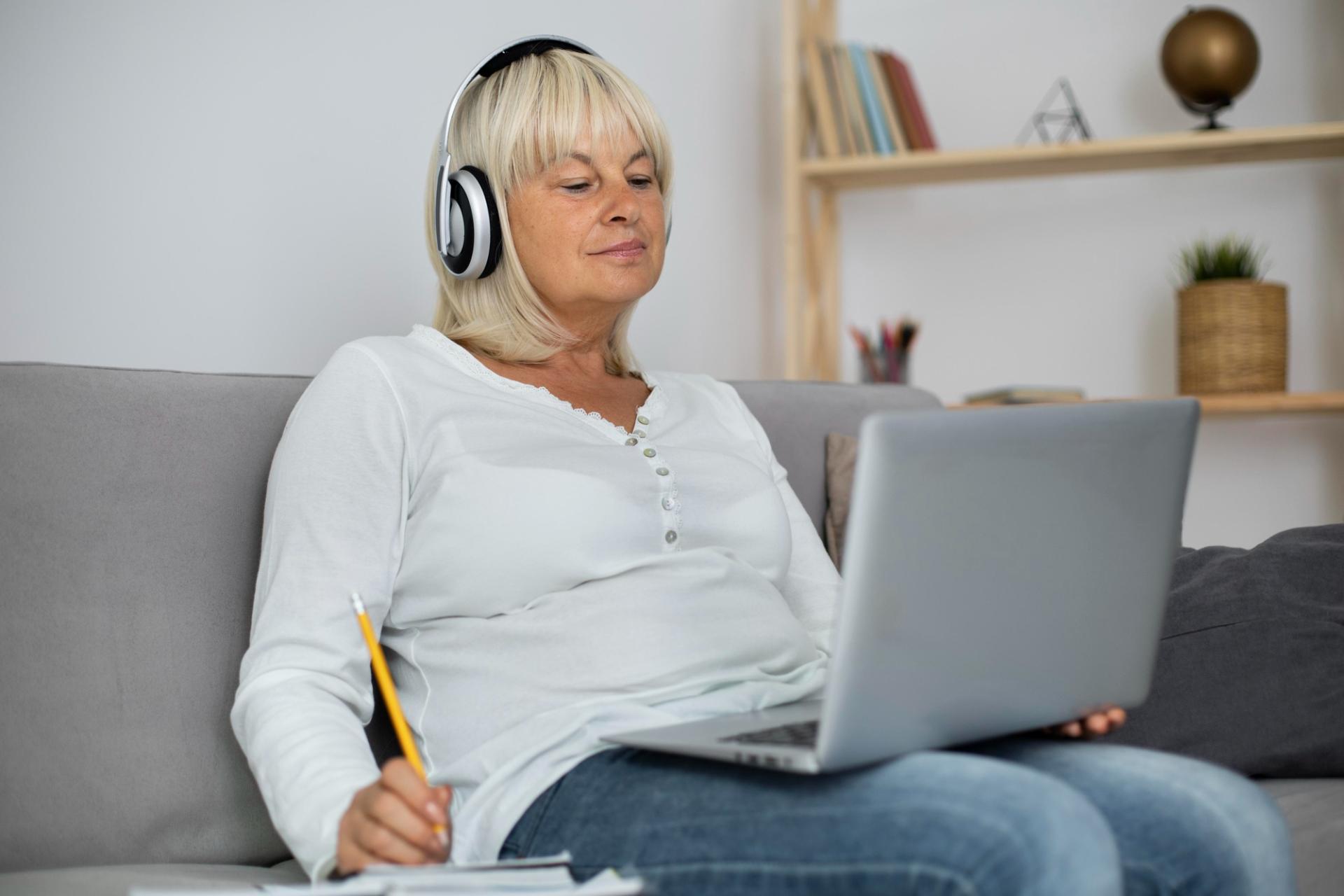 Žena středního věku se soustředí na on-line obsah.