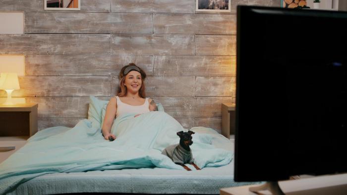 žena se svým psíkem sledují televizi.